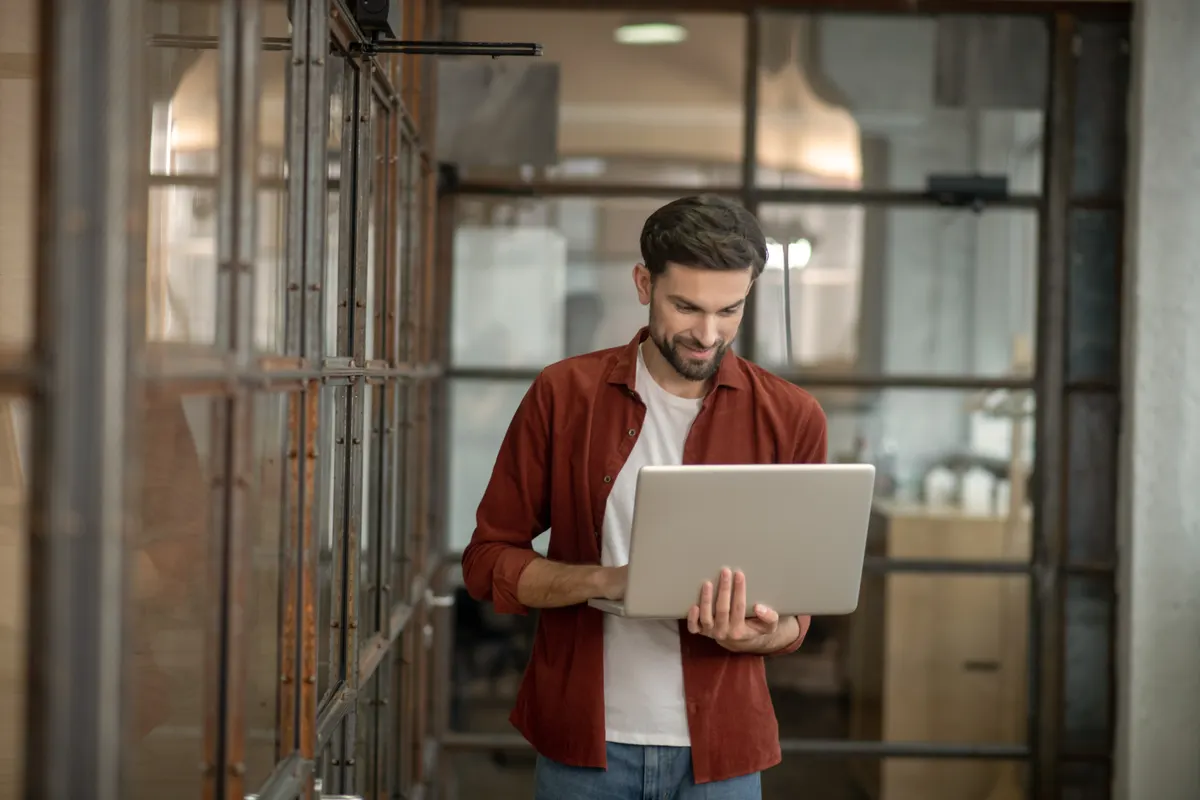 An IT professional working on a laptop in a quiet office
